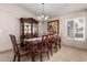 Traditional dining room featuring dark wood furniture, chandelier and plantation shutters at 13516 W Windsor Blvd, Litchfield Park, AZ 85340