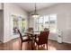 Bright dining room features wood floors, a round table, and view to the covered patio through sliding doors at 13516 W Windsor Blvd, Litchfield Park, AZ 85340