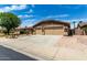 Spacious three-car garage with stone veneer accents and a wide driveway and desert landscaping at 13516 W Windsor Blvd, Litchfield Park, AZ 85340