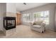 Living room with fireplace, shuttered windows and accent chair at 13516 W Windsor Blvd, Litchfield Park, AZ 85340