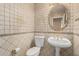 Stylish half-bathroom with decorative tile, modern fixtures, and oval mirror at 13516 W Windsor Blvd, Litchfield Park, AZ 85340