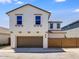 Two-story home featuring a two-car garage, a brown-tiled roof, and a light-colored stucco exterior at 14636 W Sand Hills Rd, Surprise, AZ 85387