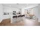 Modern kitchen with white cabinets, stainless appliances, and dining area at 14636 W Sand Hills Rd, Surprise, AZ 85387