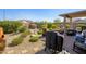 Inviting backyard with desert landscaping, covered patio, and outdoor grill perfect for entertaining at 15900 W Autumn Cir, Surprise, AZ 85374