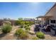 Well-maintained backyard features desert landscaping, mature bushes, and a covered patio with furniture at 15900 W Autumn Cir, Surprise, AZ 85374