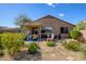 Comfortable covered patio with seating and an outdoor grill overlooking a well-landscaped backyard with gravel at 15900 W Autumn Cir, Surprise, AZ 85374