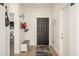 Welcoming foyer with a dark front door, light wood floors, and a bench with coat rack at 15900 W Autumn Cir, Surprise, AZ 85374