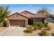 Charming single-story home with a well-manicured yard and a two-car garage on a sunny day at 15900 W Autumn Cir, Surprise, AZ 85374