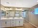 Bright bathroom featuring double sinks, white cabinets, a large mirror, and modern fixtures at 18902 W Clinton St, Surprise, AZ 85388