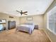 Calm primary bedroom features a ceiling fan, carpet, and neutral decor for a relaxing retreat at 18902 W Clinton St, Surprise, AZ 85388