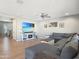 Relaxing living room featuring hardwood floors, a large sectional, a ceiling fan, and a large flat screen TV at 18902 W Clinton St, Surprise, AZ 85388