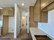 Galley view of the kitchen displaying long white countertops, shaker cabinets, and tiled floors at 1978 W Lariat Ln, Phoenix, AZ 85085