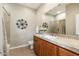 Well-lit bathroom featuring tile countertops, wood cabinets, and decorative wall art at 20750 N 87Th St # 2074, Scottsdale, AZ 85255