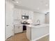 Modern kitchen featuring white cabinets, stainless steel appliances, and a center island with a sink at 21130 N 58Th St, Phoenix, AZ 85054
