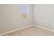 A simple bedroom with neutral carpet, walls, and trim with natural light from a window at 21240 N 58Th St, Phoenix, AZ 85054