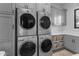 Well-equipped laundry room with grey cabinetry, countertops, and four front-loading washing/drying machines at 2742 W Monterey Pl, Chandler, AZ 85224