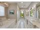 Marble main bathroom features soaking tub, double sink vanity, elegant mirrors, and a bright window view at 2742 W Monterey Pl, Chandler, AZ 85224