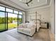 Serene main bedroom with canopy bed, lounge sofa, and a view of the lush backyard through expansive windows at 2742 W Monterey Pl, Chandler, AZ 85224
