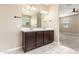 Bathroom featuring double sinks and a large mirror, connecting to a well-lit bedroom at 30303 W Whitton Ave, Buckeye, AZ 85396