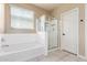 Bright bathroom with a tub, shower, and window offering natural light with tile floors at 30303 W Whitton Ave, Buckeye, AZ 85396