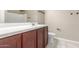 Bathroom features a sleek vanity with dark cabinets, bright countertop, and a large mirror at 30303 W Whitton Ave, Buckeye, AZ 85396