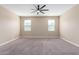 Spacious carpeted bedroom with a ceiling fan and two windows allowing natural light at 30303 W Whitton Ave, Buckeye, AZ 85396