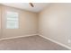 Bedroom boasts neutral paint and plush carpeting, complemented by a large, bright window at 30303 W Whitton Ave, Buckeye, AZ 85396