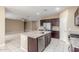 A well-lit kitchen island with a sink, flowing into a large living space with a ceiling fan at 30303 W Whitton Ave, Buckeye, AZ 85396