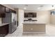 Spacious kitchen featuring dark cabinetry, stainless steel appliances, granite countertops, and a large island at 30303 W Whitton Ave, Buckeye, AZ 85396