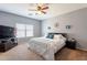 Cozy bedroom with neutral tones, ceiling fan, and comfortable bed with blue accents at 33425 N Roadrunner Ln, San Tan Valley, AZ 85144