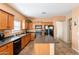 Functional kitchen features wood cabinetry, a center island, black appliances and tile flooring at 33425 N Roadrunner Ln, San Tan Valley, AZ 85144