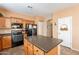 Functional kitchen features wood cabinetry, a center island, black appliances and tile flooring at 33425 N Roadrunner Ln, San Tan Valley, AZ 85144