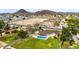 An aerial view of a home with a pristine pool, expansive lawn, and mountain views at 4211 W Yorkshire Dr, Glendale, AZ 85308