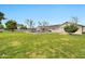 Expansive backyard with lush green grass, swimming pool, covered patio, and charming single-story home at 4211 W Yorkshire Dr, Glendale, AZ 85308