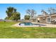 Landscaped backyard featuring a refreshing swimming pool, covered patio, and lush green lawn at 4211 W Yorkshire Dr, Glendale, AZ 85308