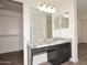 Bathroom showcasing granite countertop vanity, large mirror, and walk-in closet at 43857 W Bedford Dr, Maricopa, AZ 85138