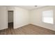Bright bedroom with wood flooring, white walls, and a large window at 43857 W Bedford Dr, Maricopa, AZ 85138