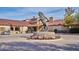 Elegant clubhouse entrance with horse statue, stone accents, colorful flowers, and golf carts at 43857 W Bedford Dr, Maricopa, AZ 85138