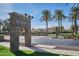 Stone entrance sign reading 'Rancho El Dorado', framed by palm trees and manicured landscaping at 43857 W Bedford Dr, Maricopa, AZ 85138