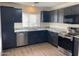 Modern kitchen features stainless steel appliances, granite countertops, and dark wood cabinets at 43857 W Bedford Dr, Maricopa, AZ 85138