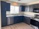 Modern kitchen features stainless steel appliances, granite countertops, and dark wood cabinets at 43857 W Bedford Dr, Maricopa, AZ 85138