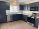Modern kitchen features stainless steel appliances, granite countertops, and dark wood cabinets at 43857 W Bedford Dr, Maricopa, AZ 85138
