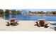 Scenic view of a serene lake with picnic tables on the waterfront and water fountain feature at 43857 W Bedford Dr, Maricopa, AZ 85138