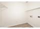 Clean laundry room featuring washer/dryer hookups, shelf, and vinyl flooring at 43857 W Bedford Dr, Maricopa, AZ 85138