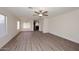 Open-concept living room with wood flooring, a ceiling fan, and a view of the kitchen at 43857 W Bedford Dr, Maricopa, AZ 85138