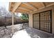 Covered patio featuring a secure metal screen door, views of the back yard and mature landscaping at 43857 W Bedford Dr, Maricopa, AZ 85138