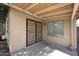 Covered patio with a screen door, window, and brick accents, offering a comfortable outdoor living space at 43857 W Bedford Dr, Maricopa, AZ 85138