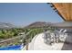 Balcony featuring dining set with stunning views of a lush landscape and a glistening swimming pool at 4550 E Foothill Dr, Paradise Valley, AZ 85253