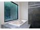 Bathroom featuring a soaking tub, mosaic tile accents, and large window with natural light at 4550 E Foothill Dr, Paradise Valley, AZ 85253