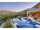 Gorgeous backyard infinity pool with lush landscaping and views of the surrounding mountains at 4550 E Foothill Dr, Paradise Valley, AZ 85253